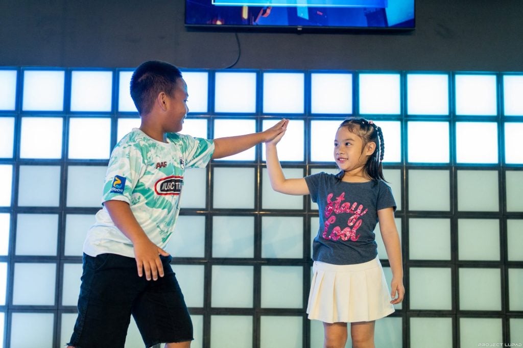 Kids giving each other a high five on the glowing LED floor