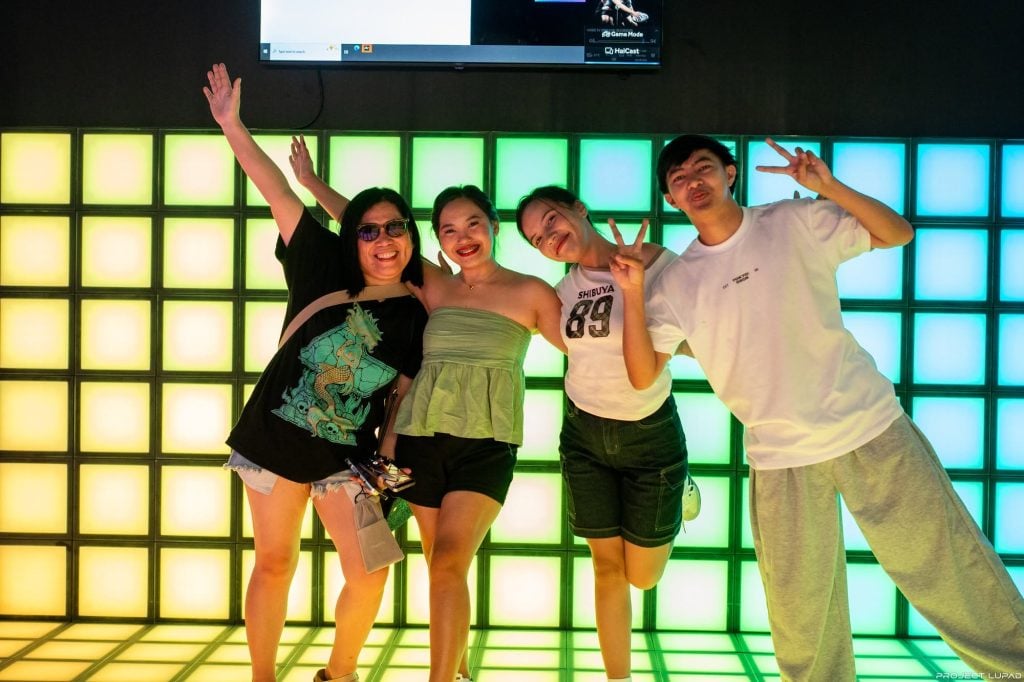 Friends posing in front of the glowing LED wall at Limketkai Mall